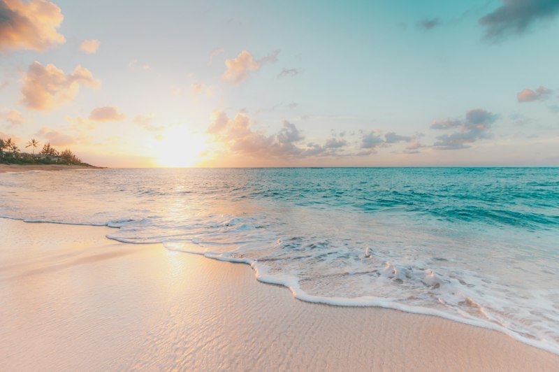 Ocean word search puzzles — gentle waves on a sandy beach at sunset