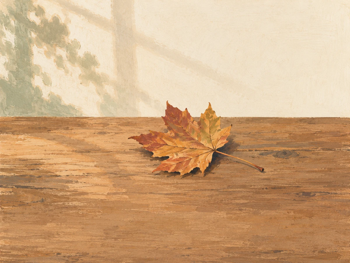 Fall word search, easy — painted illustration of a single maple leaf on a wooden table